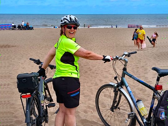 Kathy with bikes on the sandy beach